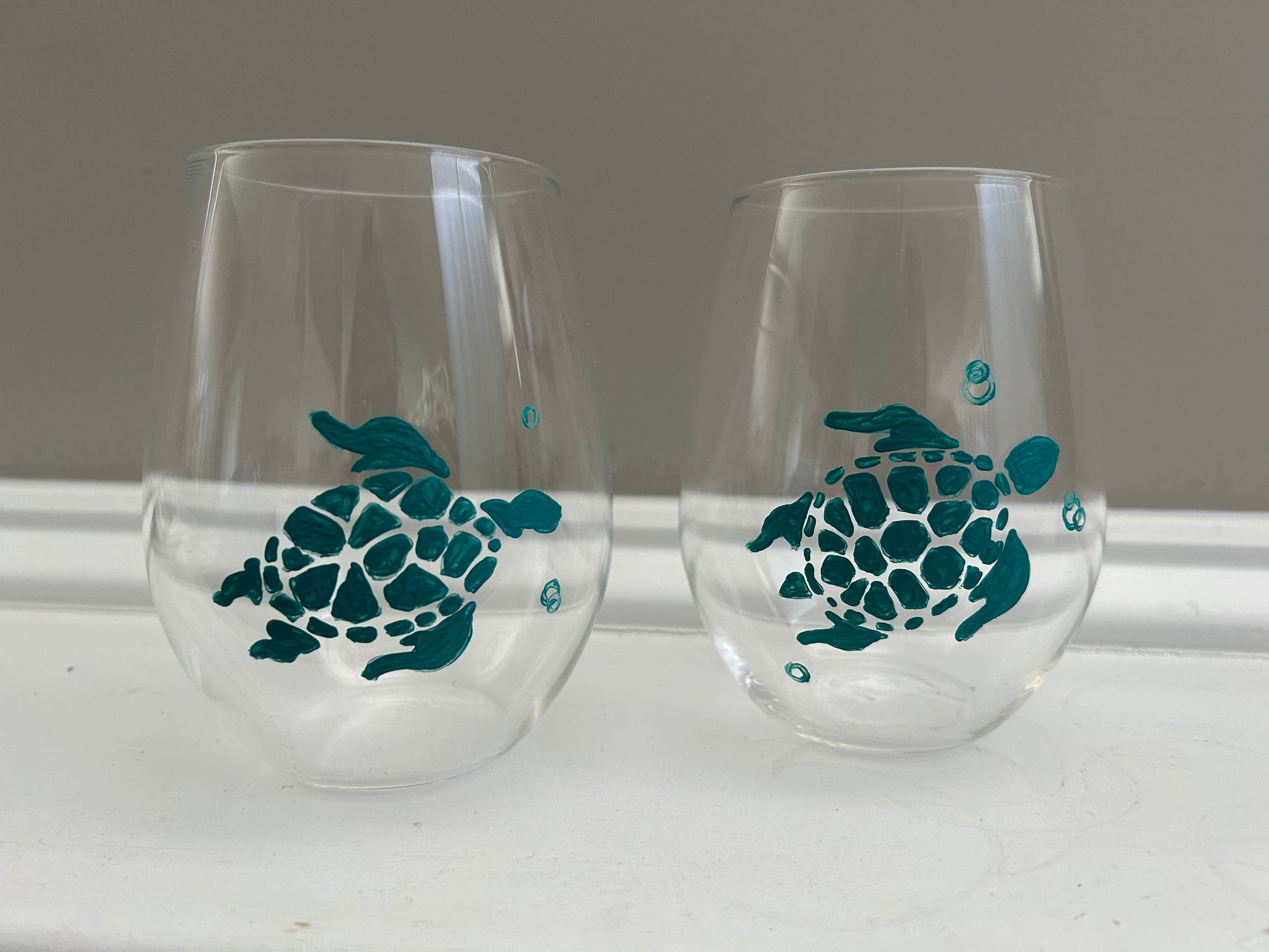 Hand-painted stemless wine glasses painted with teal sea turtles