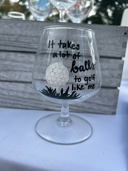 Hand-painted manhattan cocktail glass with painted golf ball and "It takes a lot of balls to golf like me" written in calligraphy