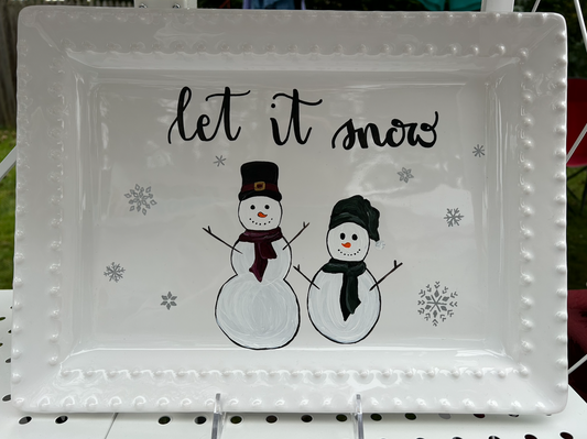 Hand-painted snowmen and snowflakes with "Let it Snow" written in calligraphy on a serving platter